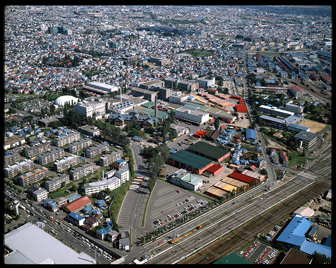 1980年代と思われるサッポロビール第二工場全景（写真提供：サッポロビール株式会社）と、工場跡地の開発計画によって2005年11月に開業した「Ａrio（アリオ）札幌」。